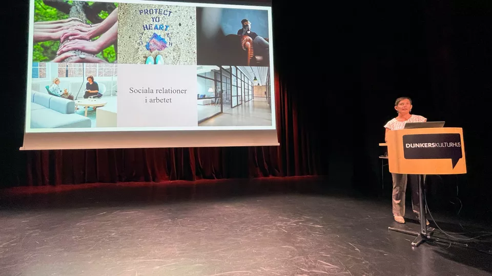 Foto visar Malin Espersson som står på scen och föreläser.