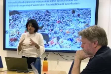 Bilden visar Manisha Anantharaman framför en skärm med bild på avfall och en avfallsarbetare