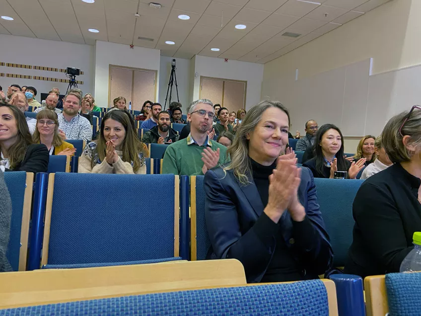 Bild på publik som applåderar i föreläsningssal